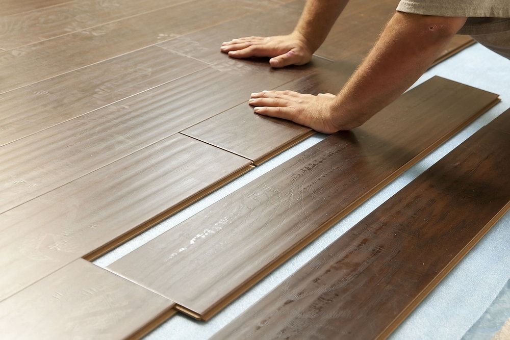 Flooring installation with wood planks being laid