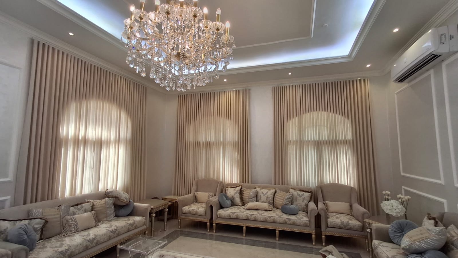Elegant living room with floor-to-ceiling curtains and crystal chandelier