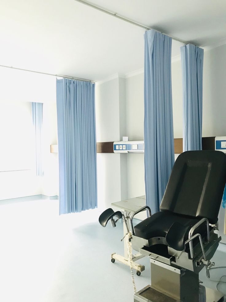 Hospital room with blue medical curtains on ceiling track