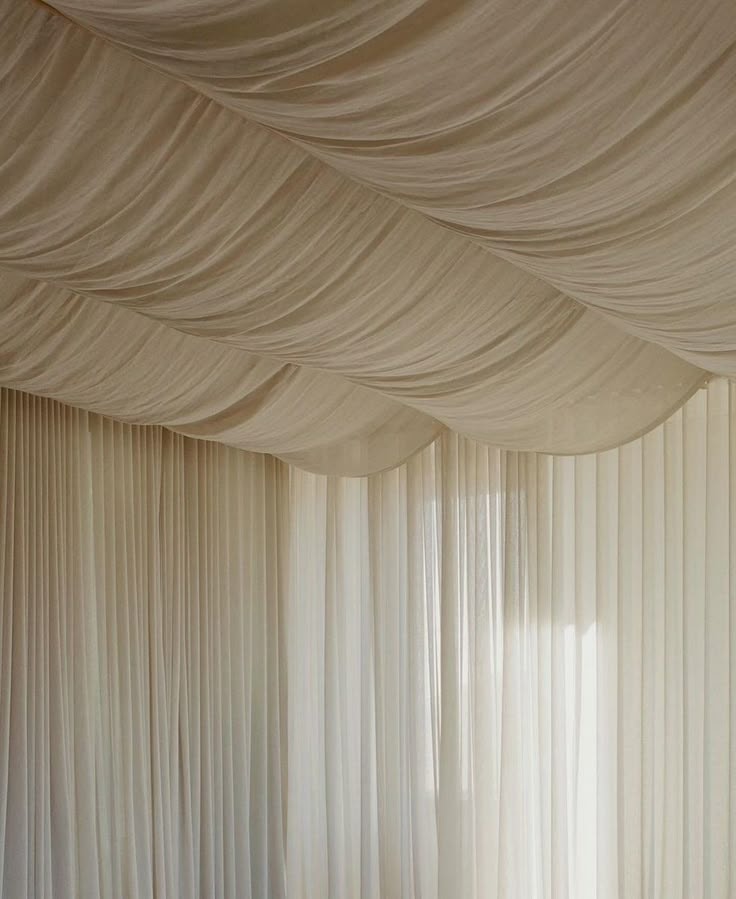 Elegant event venue with draped fabric backdrop and chandelier