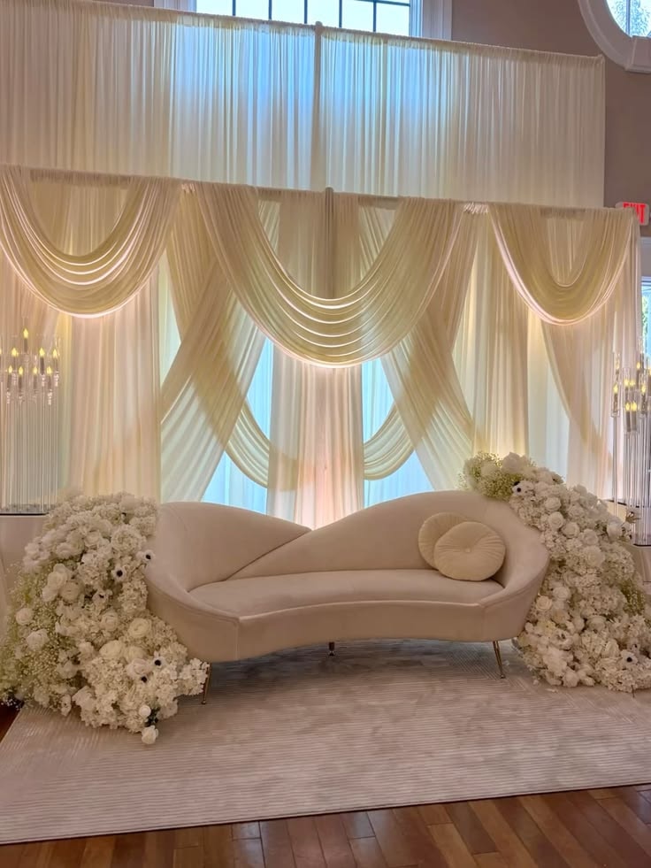 Elegant lounge setup with draped backdrop and curved sofa