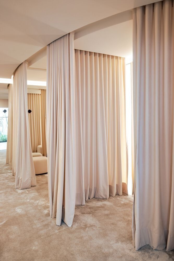 Luxury showroom with floor-to-ceiling cream drape curtains